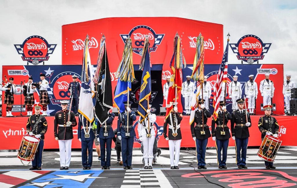 service members hold flags during military tribute